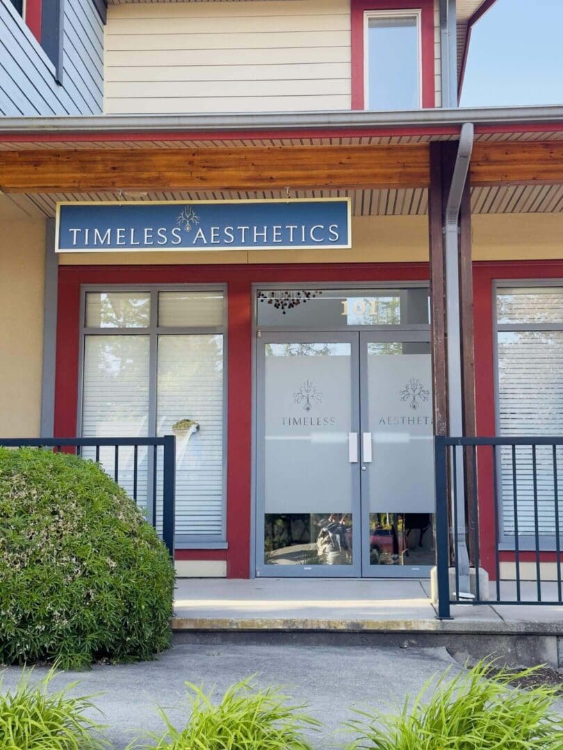 Front entrance of Timeless Aesthetic with glass doors and a wooden frame.