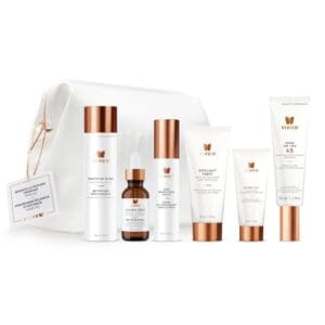 Set of skincare products with white and copper packaging and a white pouch.