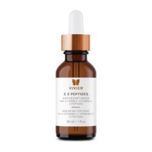 Brown glass dropper bottle of facial serum with white label and copper cap.