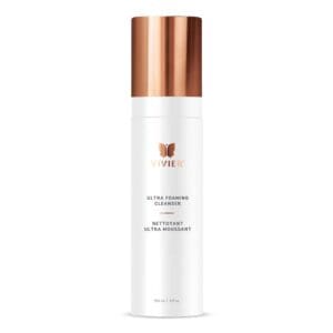 White skincare bottle with a copper cap labeled 'Vitamin C Brightening Essence'.