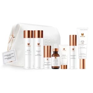 A set of white and copper skincare products with a matching pouch.